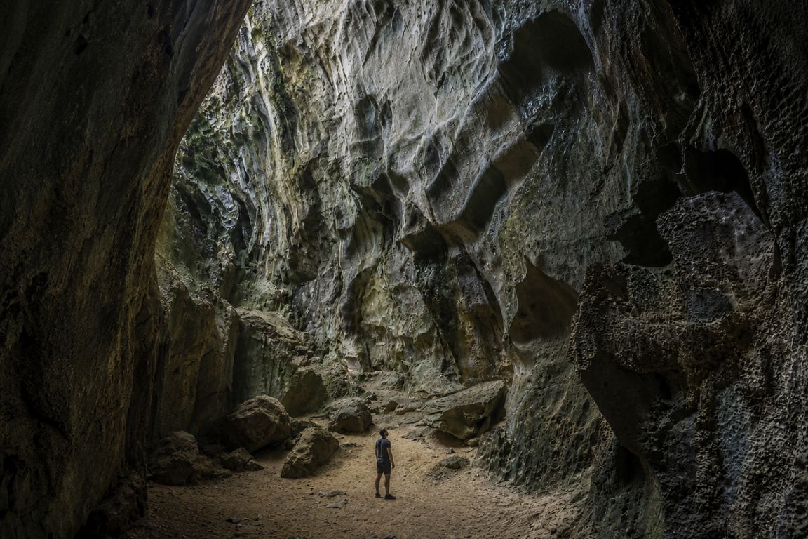Traveler standing inside the massive Cudugnon Cave during a guided island hopping tour with El Nido Tours