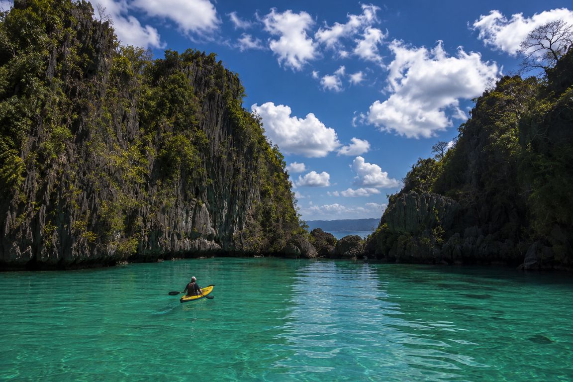 Kayaking through the crystal-clear waters of Small Lagoon during an island hopping tour with El Nido Tours